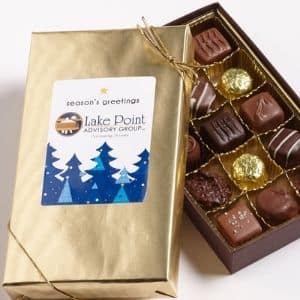 Box of Assorted chocolates wrapped in gold paper with a company logo on a sticker
