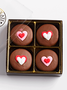 4 valentine's chocolate sandwich cookies with heart icing decals in a box