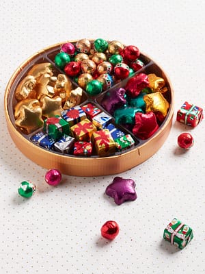 round tray filled with foil chocolate stars, presents and balls in assorted colors