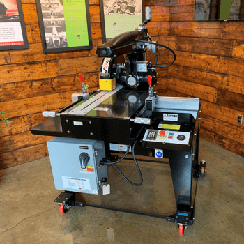 Sustainability focus - Radial Arm Saw in front of a reclaimed wood wall in the Original Saw Company's showroom.