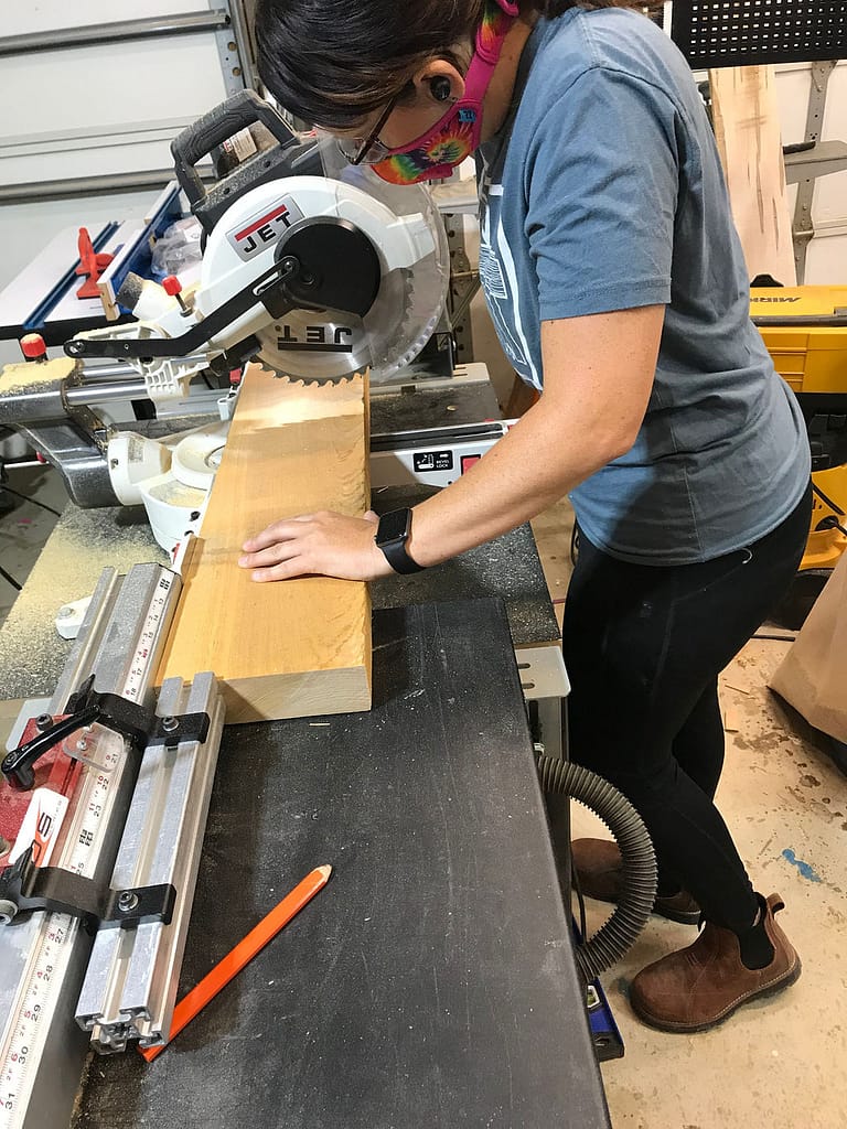 Woman using Original Saw's Woodcuting Station to cut wood.