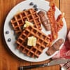chocolate covered bacon and waffles on plate