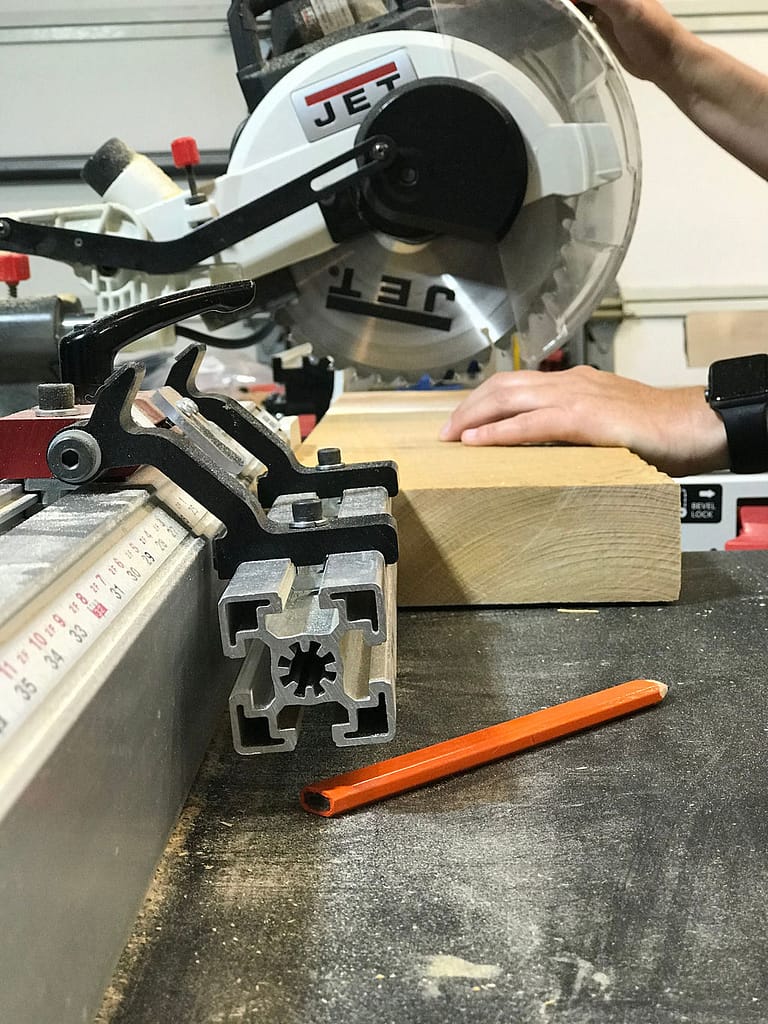 Cutting wood with a miter saw and utilizing Original Saw Company's Wood Cutting Station with a Miter Saw Stand, Saw Measuring System and Saw Extension Tables.
